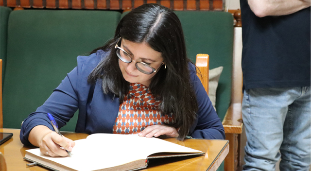 La delegada de inclusión firmando en un libro