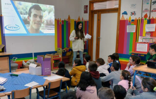Los niños sentados en el suelo escuchando a una persona del centro de día hablar sobre las personas con discapacidad intelectual