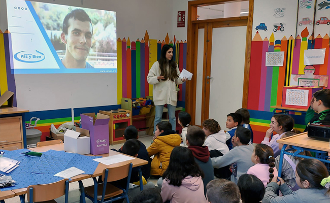 Los niños sentados en el suelo escuchando a una persona del centro de día hablar sobre las personas con discapacidad intelectual