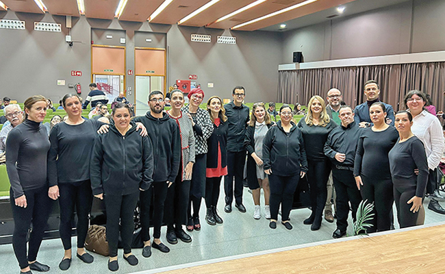El grupo de danza Zyrdanza posa en un auditorio tras su presentación. La imagen refleja la inclusión y participación activa de personas con discapacidad intelectual en Sevilla, destacando su talento.